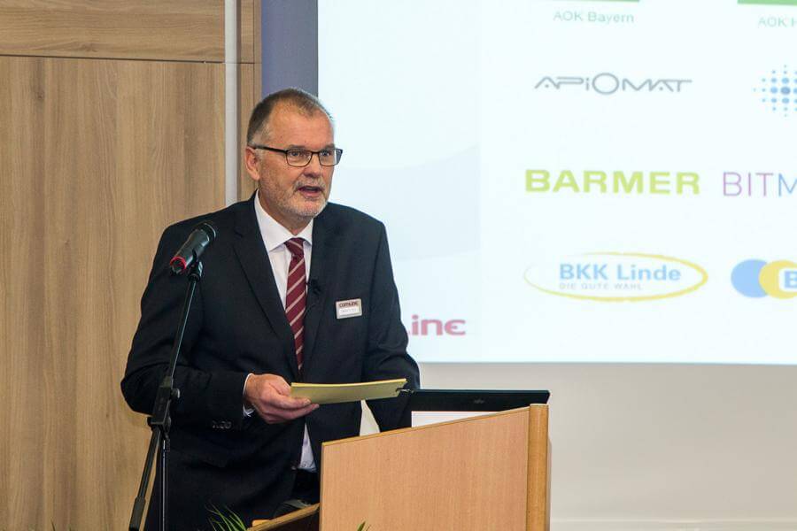 Moderation Digitalisierung Krankenkassen Cmline Vorstand Stephan Schilling hält die Eröffnungsrede am Pult